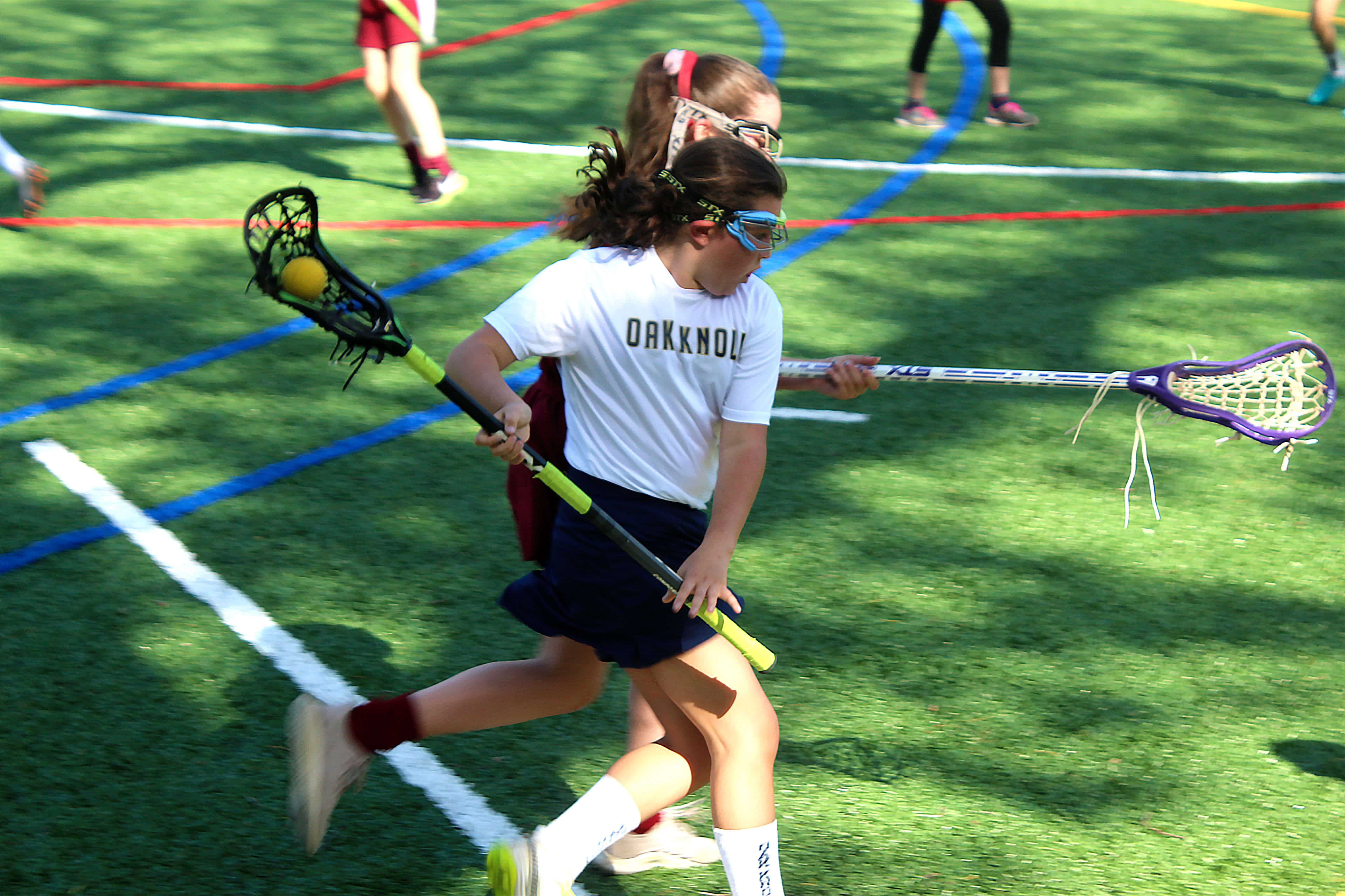 Female Lower School lacrosse player during a game at Oak Knoll