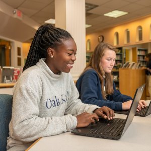 Upper School students working in the library on computers.