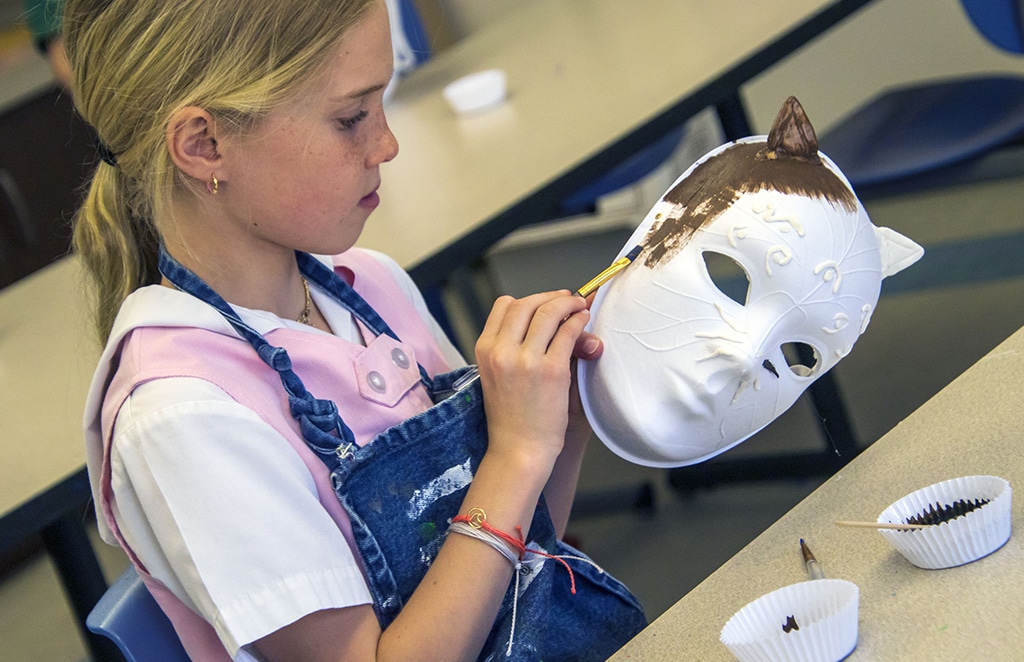 Student paints mask during art class.