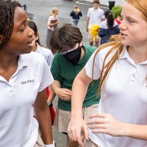 Middle school students chat while walking on campus.