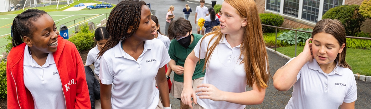 Middle school students chat while walking on campus.